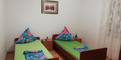 a room with two beds and a table at Apartmani kod Rade in Pakoštane
