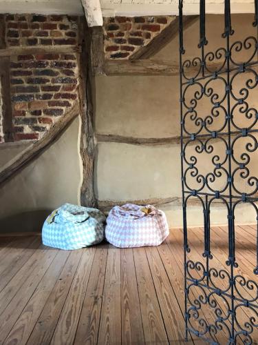 dois cestos sentados num chão de madeira ao lado de um portão de ferro em « Le LoMa » Ancienne fermette em Hotton