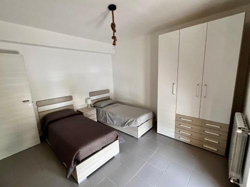 a bedroom with two beds and a closet at Appartamento La Rondine in Pignataro Maggiore