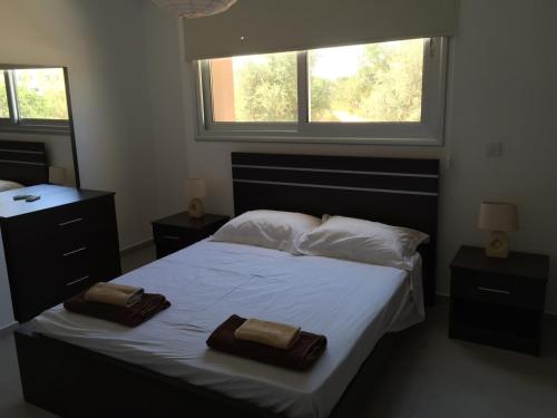 a bedroom with a bed with two towels on it at Niro Apartments in Polis Chrysochous