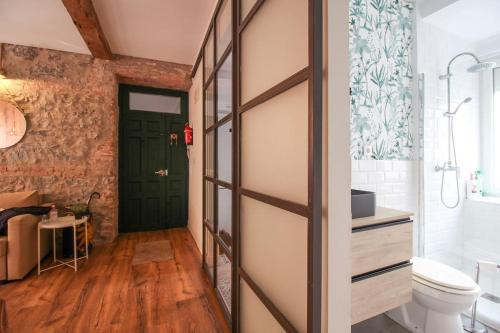 a bathroom with a green door and a toilet at La casita de Lola in Santander