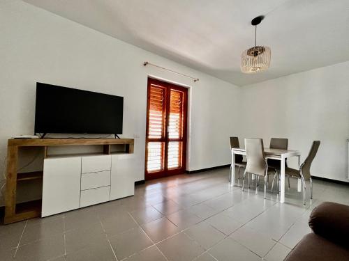 a living room with a television and a table with chairs at Appartamento La Rondine in Pignataro Maggiore