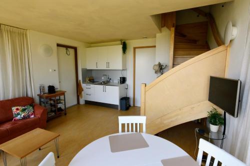 a living room with a table and a staircase at De Kinkhoorn in Ezinge