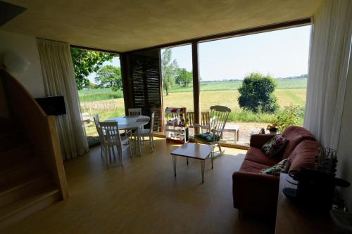 sala de estar con sofá, mesa y sillas en De Kinkhoorn, en Ezinge