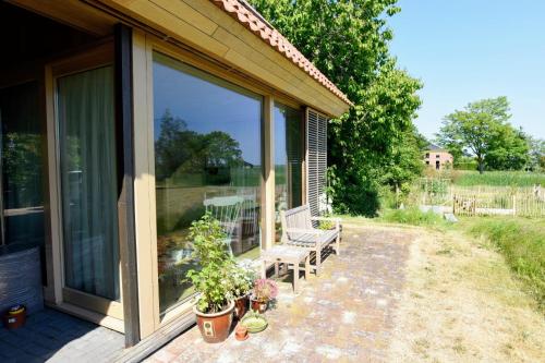 a screened in porch with a bench and plants at De Kinkhoorn in Ezinge