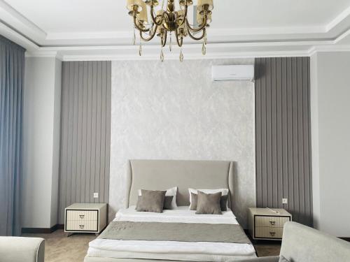 a bedroom with a large bed and a chandelier at IMPERIAL in Taraz
