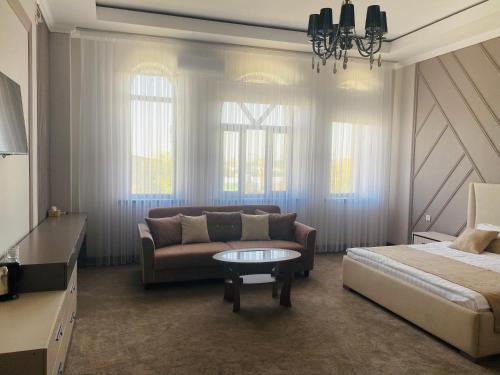 a living room with a couch and a bed and a table at Dinar in Taraz