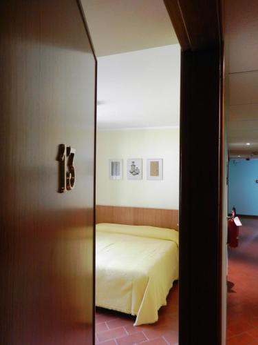 ボッシコにあるAlbergo Milanoのベッドルーム1室(ガラスドアで仕切られたベッド1台付)