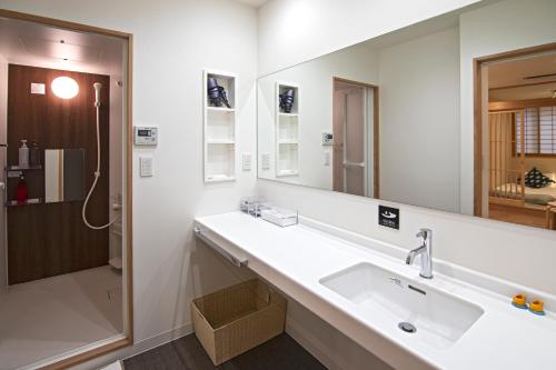 een badkamer met een wastafel en een spiegel bij 拾野の家 202和室 in Osaka