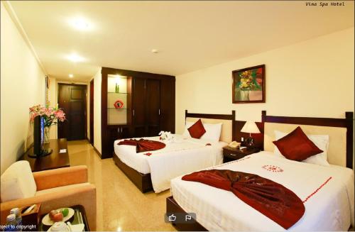 a hotel room with two beds and a couch at Việt Nam Hotel in Hue