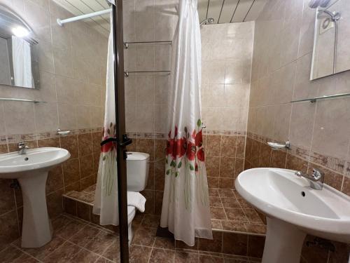 a bathroom with two sinks and a toilet and a mirror at Room in BB - Hotel Moura Double Room in Borovets