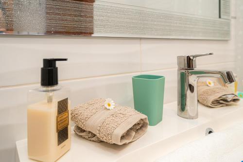 ein Waschbecken mit einer Flasche Seife und Handtüchern in der Unterkunft Relaxing zen Capnegret 2 in Altea
