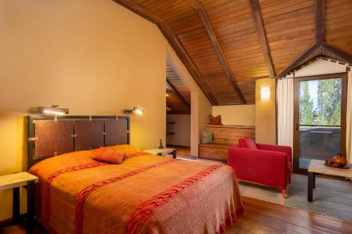 a bedroom with a bed and a red chair at Tufenkian Avan Marak Tsapatagh Hotel in Kzylkʼend