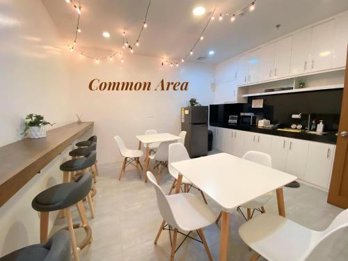 a room with tables and chairs and a kitchen at ECCO Suites Baguio in Baguio