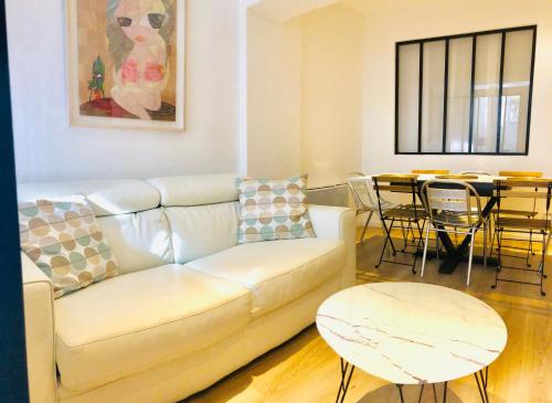 ein Wohnzimmer mit einem Sofa und einem Tisch in der Unterkunft PERE LACHAISE - MONTMARTRE Paris centre in Paris