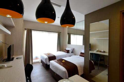 a hotel room with two beds and a mirror at Student Park Hotel in Yogyakarta