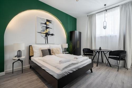 een slaapkamer met een bed met een groene muur bij R6 - Boutique Apartments, Best Location By BQA in Boedapest