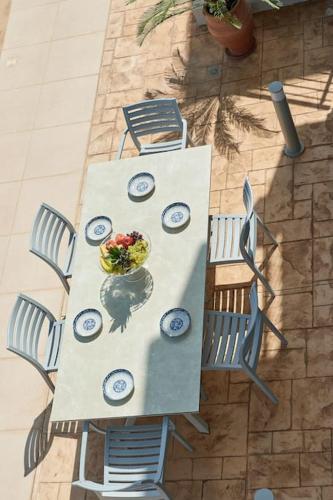 a table with chairs and a bowl of food on it at New Crete apartment in Stavromenos Coast w/pool in Stavromenos