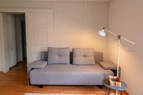 a living room with a couch and a lamp at Haus Maschol in Wald am Arlberg