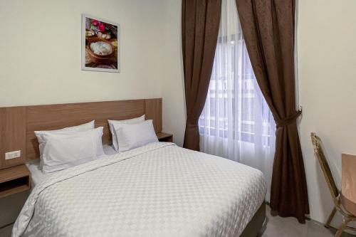 Ліжко або ліжка в номері Moresto Hotel Mitra RedDoorz