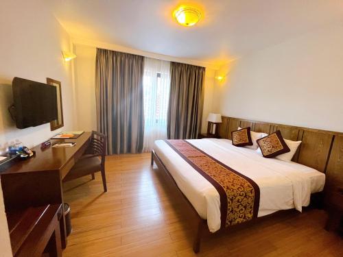 a hotel room with a large bed and a desk at Con Dao Resort in Con Dao