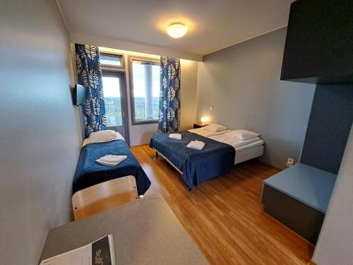 a small room with two beds and a window at Aparthotel Simpsiönkullas in Lapua