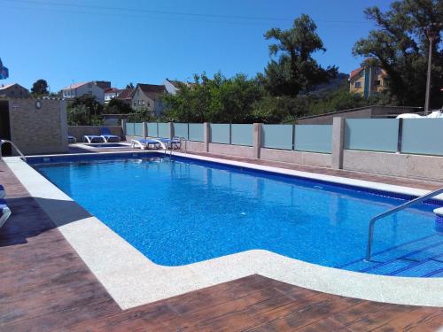 einen Pool mit blauem Wasser auf einer Holzterrasse in der Unterkunft Hotel Agarimo playa Areas in Areas