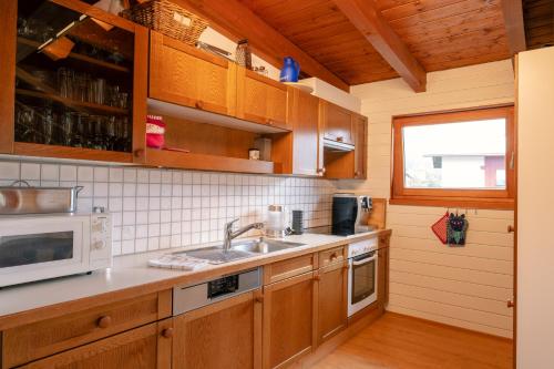 a kitchen with a sink and a microwave at Haus Maschol in Wald am Arlberg