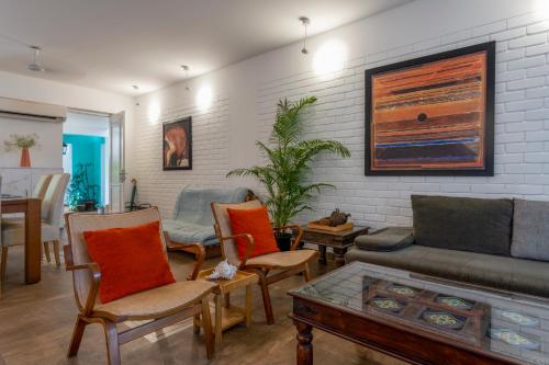a living room with a couch and chairs and a table at Santa Tera Homely 1&2bhk Apartments With Common Pool & Kitchen & Security & Wifi, Near to Candolim in Verem