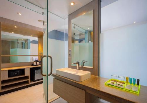 La salle de bains est pourvue d'un lavabo et d'un miroir. dans l'établissement Solia Legian Bali, à Legian