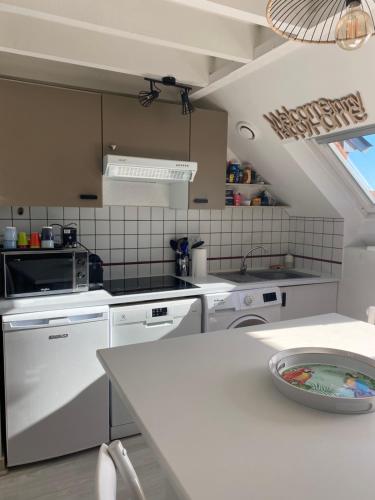 uma cozinha com electrodomésticos brancos e uma bancada branca em T2 - T3 Vue exceptionnelle - Centre ville de Dinard em Dinard