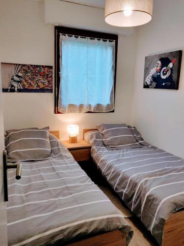 deux lits dans une chambre avec une fenêtre dans l'établissement Appartement T2 46m2 avec grande terrasse, à Sanary-sur-Mer
