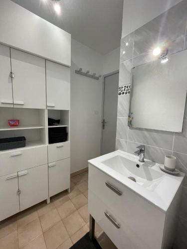 une salle de bain blanche avec un lavabo et un miroir dans l'établissement Appartement T2 46m2 avec grande terrasse, à Sanary-sur-Mer