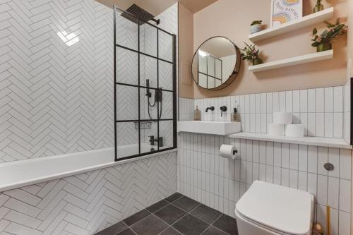 a bathroom with a toilet and a mirror at Large river view room in London