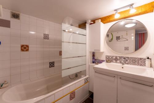 La salle de bains est pourvue d'une baignoire, d'un lavabo et d'un miroir. dans l'établissement Aux portes de la Camargue, à Manduel