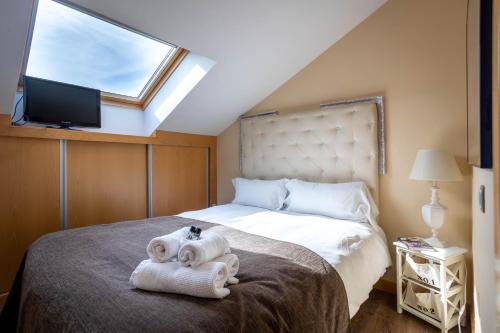 ein Schlafzimmer mit einem Bett mit Handtüchern und einem Fenster in der Unterkunft Atico Eufrasio in Lerma