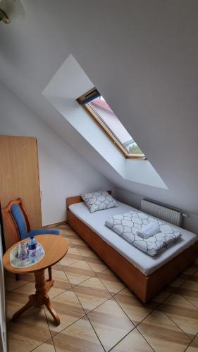 um pequeno quarto com uma cama e uma mesa em Zajazd Stradomia em Stradomia Wierzchnia
