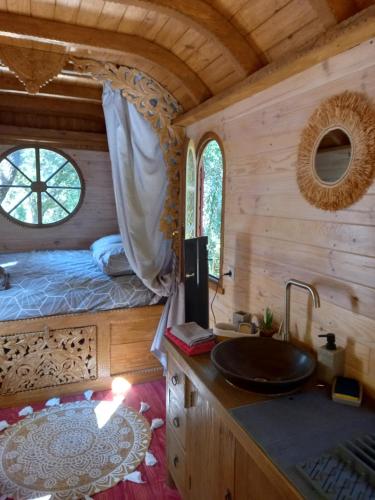 1 dormitorio con 1 cama y baño con lavabo. en La roulotte du petit paradis, en Saint-Rémy-de-Provence