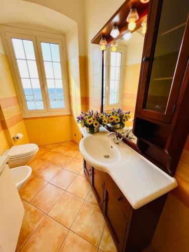 a bathroom with a sink and a toilet and a mirror at Casa Biondina in Santo Stefano al Mare