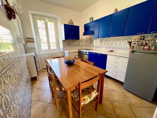 a kitchen with a wooden table and blue cabinets at Casa Biondina in Santo Stefano al Mare