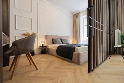 a bedroom with a bed and a chair and a television at GENeve - old town apartment Bratislava in Bratislava
