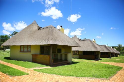 une rangée de cabanes au toit de chaume dans l'établissement Impangele Lodge, à Muldersdrift