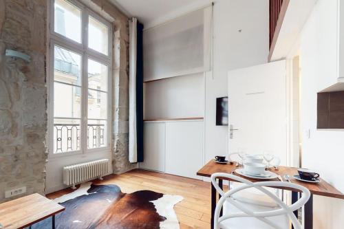 une salle à manger avec une table et une fenêtre dans l'établissement Chez Gustave: CLIM Calm,Saint Paul Marais, 2Guests, à Paris