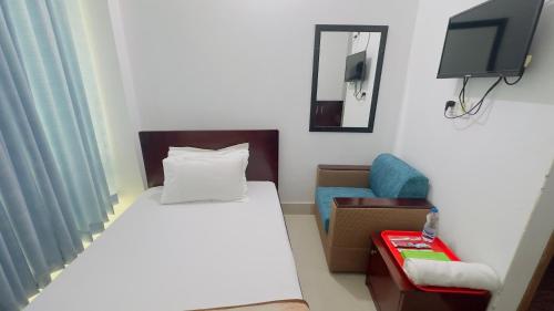 een slaapkamer met een bed, een tv en een stoel bij Hotel City Panthapath in Dhaka