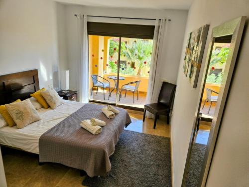 een slaapkamer met een bed met twee handdoeken erop bij Ground floor 2 bed apartment with 5 pools and large terrace in Manilva