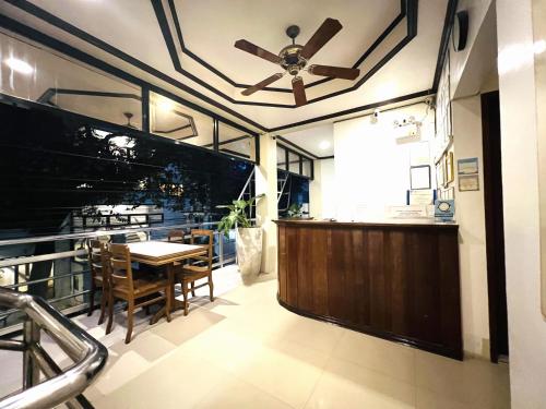 uma sala de jantar com uma ventoinha de tecto e uma mesa em Alocasia Hostel em El Nido