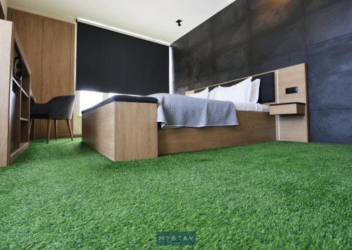 a bedroom with a bed with green grass on the floor at Hotel Lena Village in Mortágua
