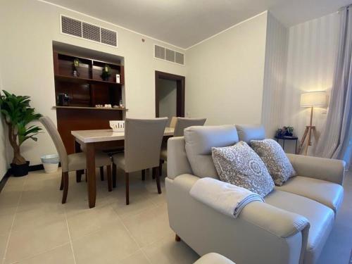 ein Wohnzimmer mit einem Sofa und einem Esszimmer in der Unterkunft Marina Deluxe 2, family only in King Abdullah Economic City
