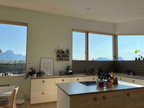 a kitchen with large windows and a counter top at House in Lofoten, beautiful view/ Hus i Lofoten in Kabelvåg