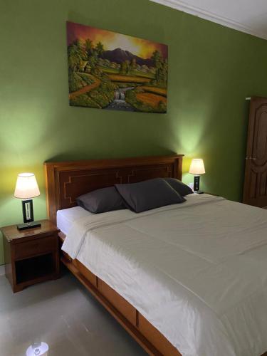 - une chambre avec un grand lit et deux lampes dans l'établissement Villa Buahan, à Bangli